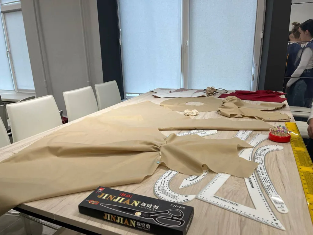 Робочий стіл із тканинами та інструментами для крою.