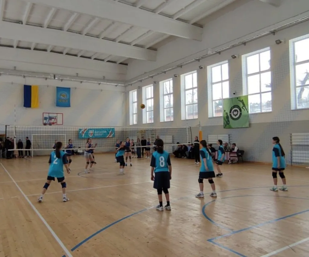 Дівчата грають у волейбол у спортивній залі