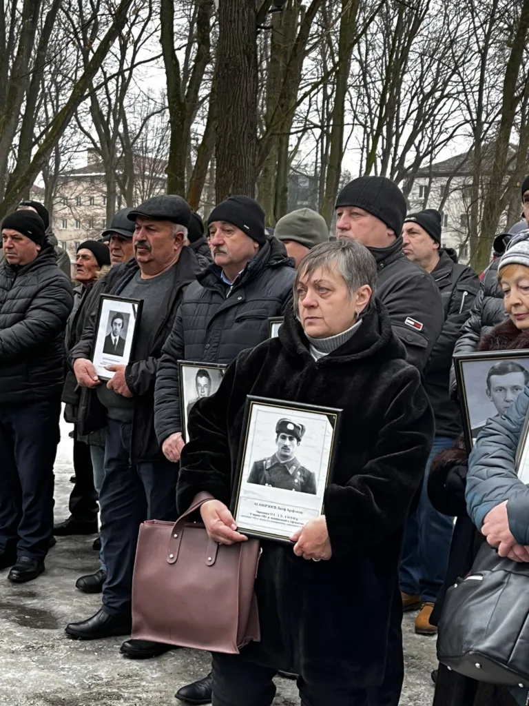 Люди тримають портрети полеглих героїв на вшануванні