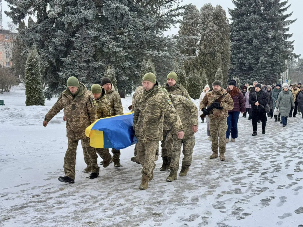 Військові несуть труну з українським прапором