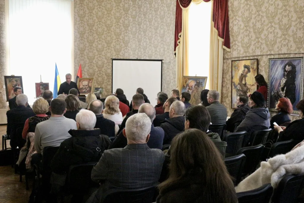 Лекція перед аудиторією у залі з картинами