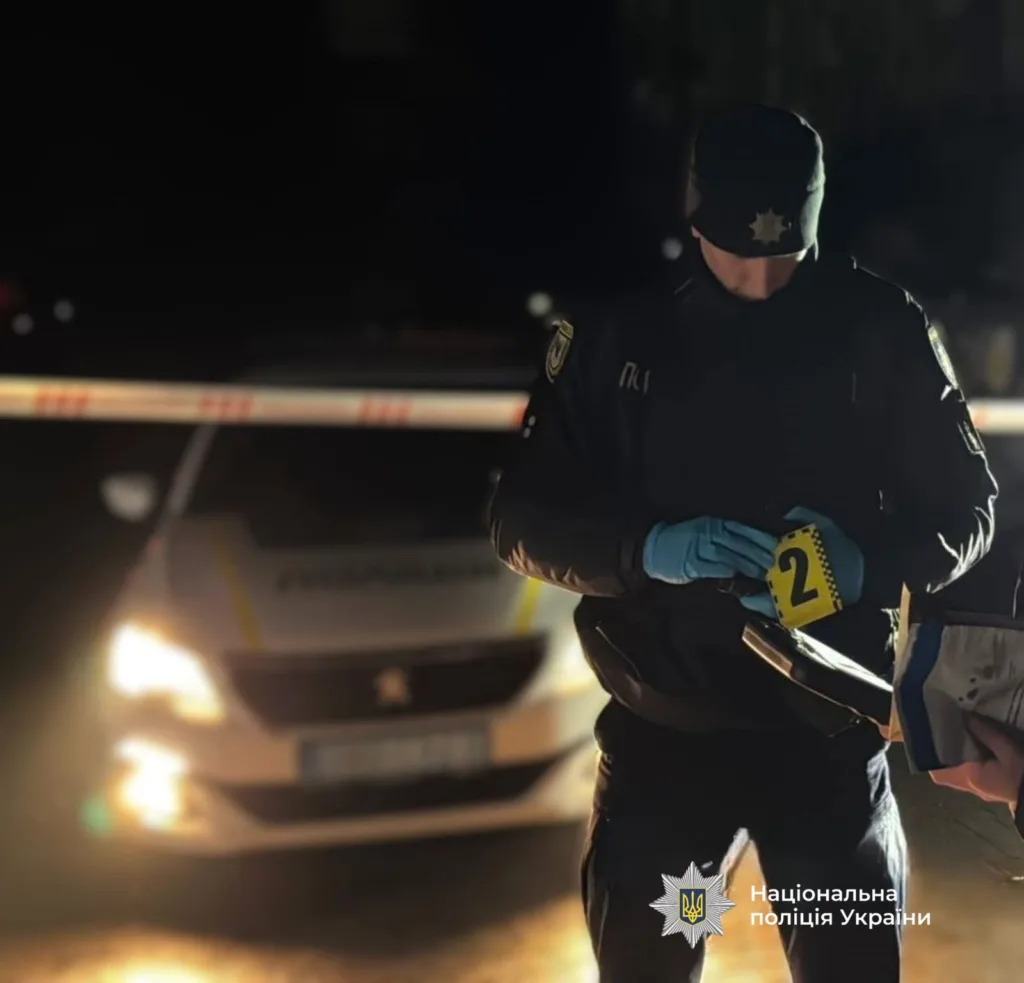Поліцейський досліджує місце злочину вночі