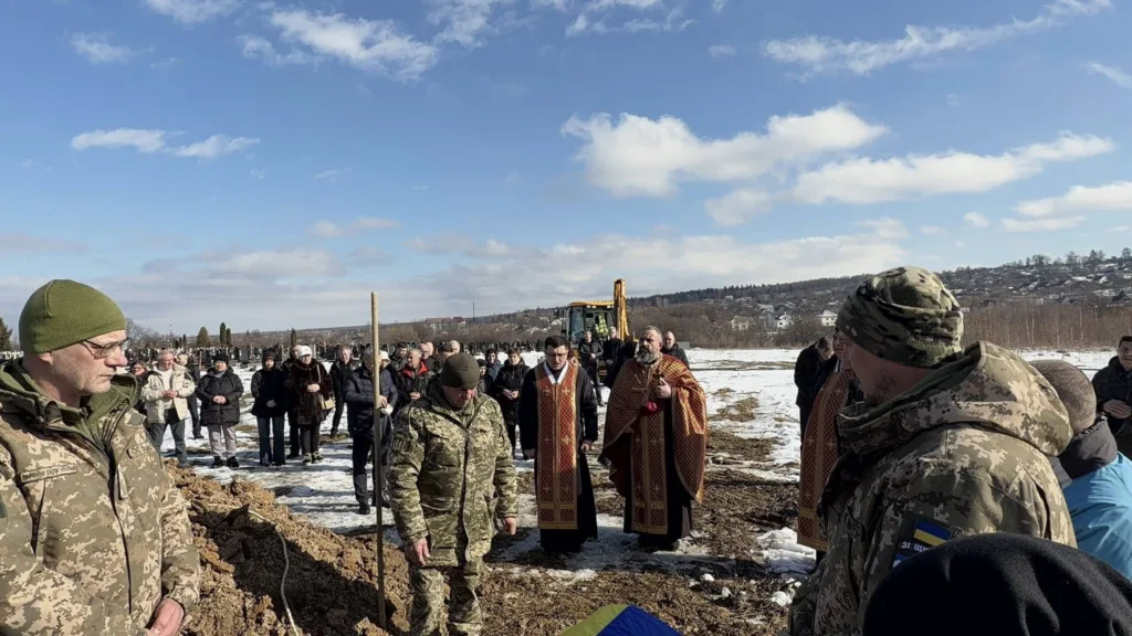 Військові та священники на зимовому похороні