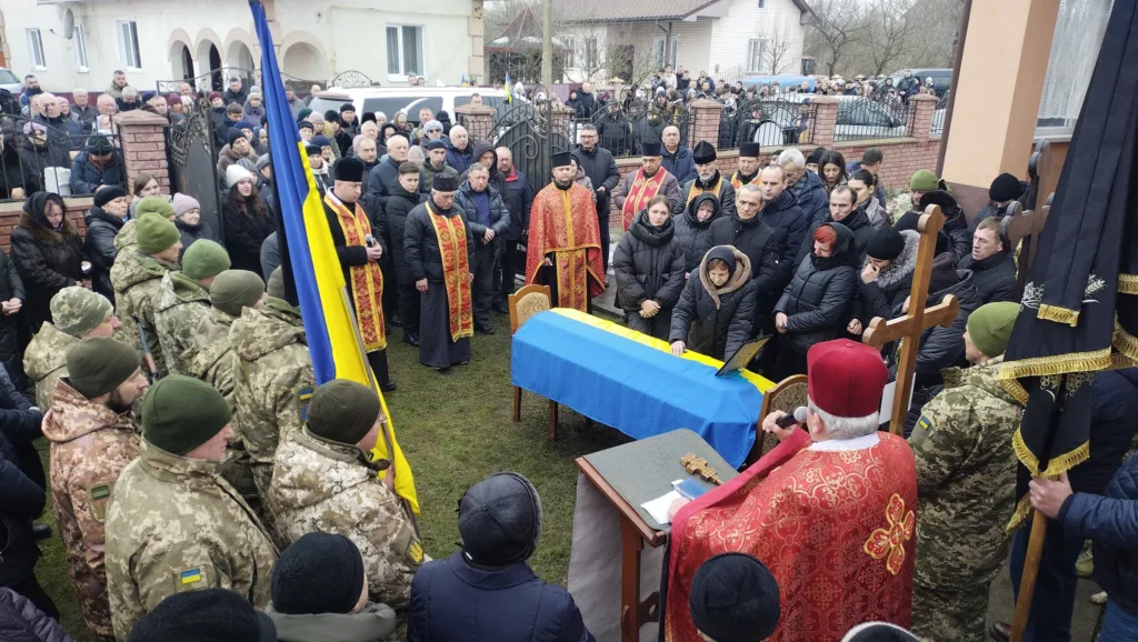 Похоронна церемонія українського військового з прапором України