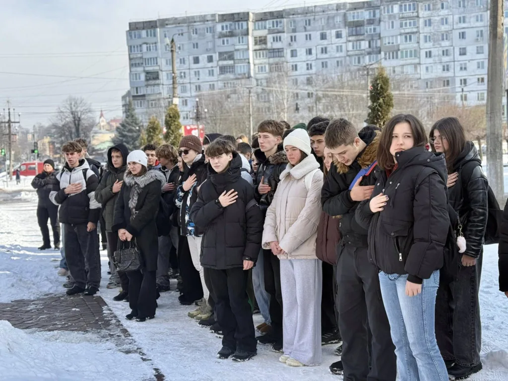 Група людей стоїть на вулиці взимку
