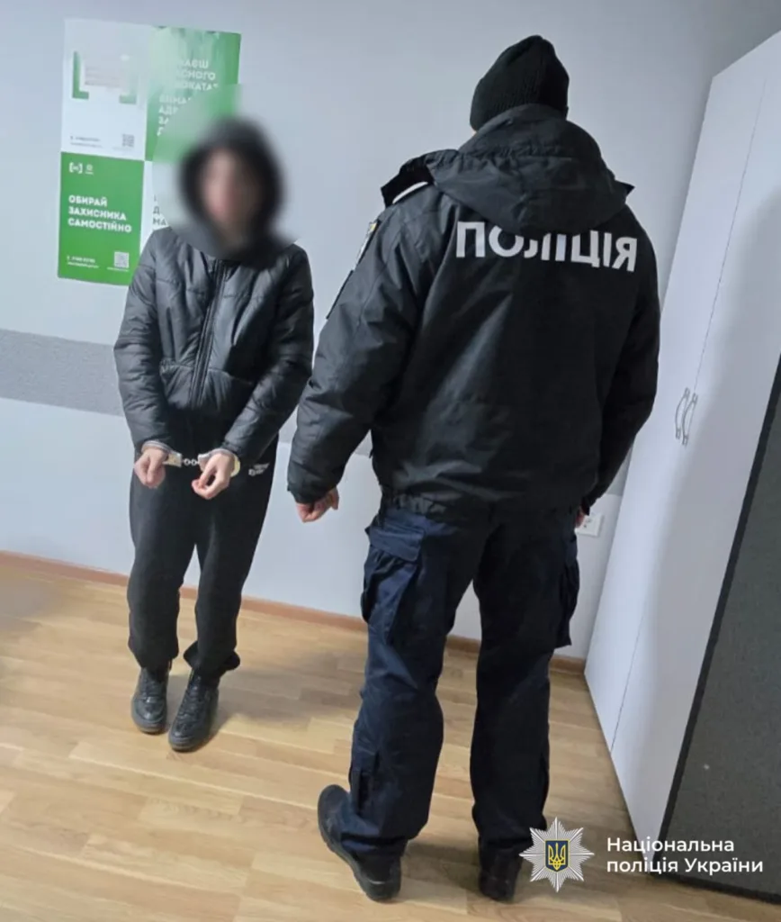 Поліцейський затримує людину в наручниках