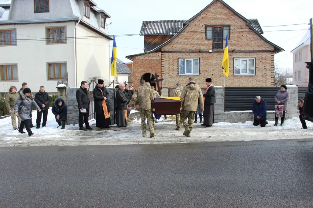 Військові несуть труну під українським прапором