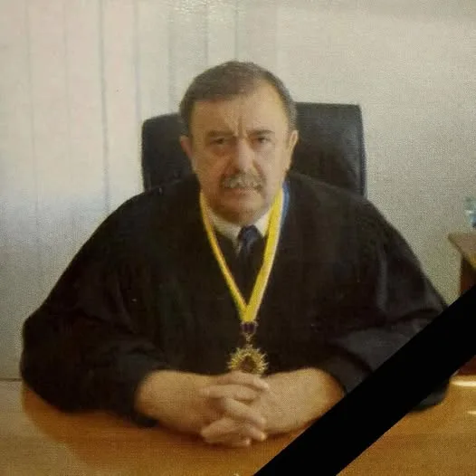 Суддя сидить за столом у мантії