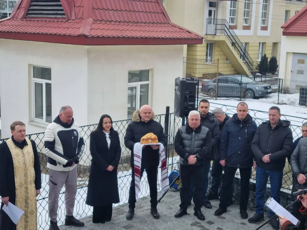 Люди на вуличній церемонії взимку біля будівлі