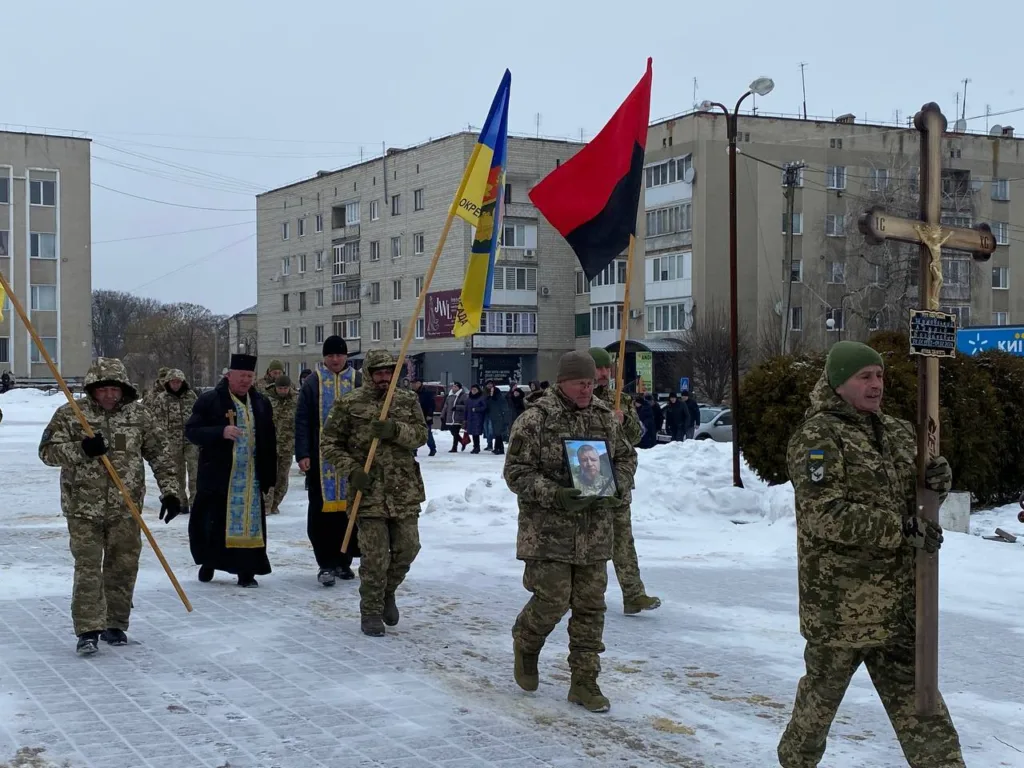 Військові несуть прапори та хрест під час церемонії