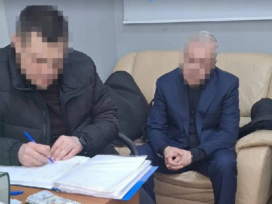 Двоє чоловіків сидять за столом з документами