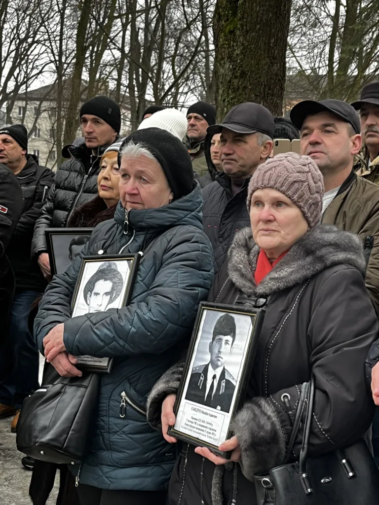 Люди тримають фотографії загиблих на пам'ятному заході