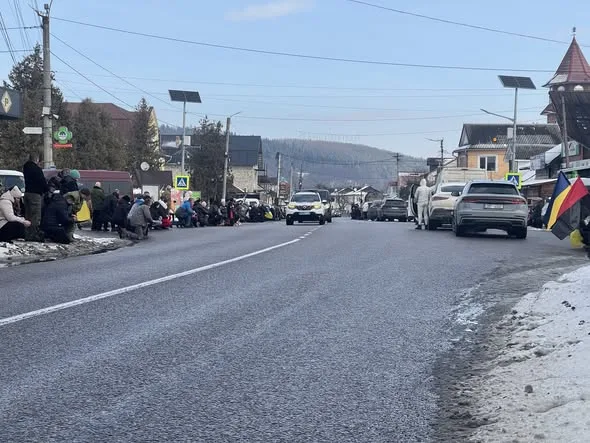 Люди сидять вздовж зимової вулиці в гірському місті