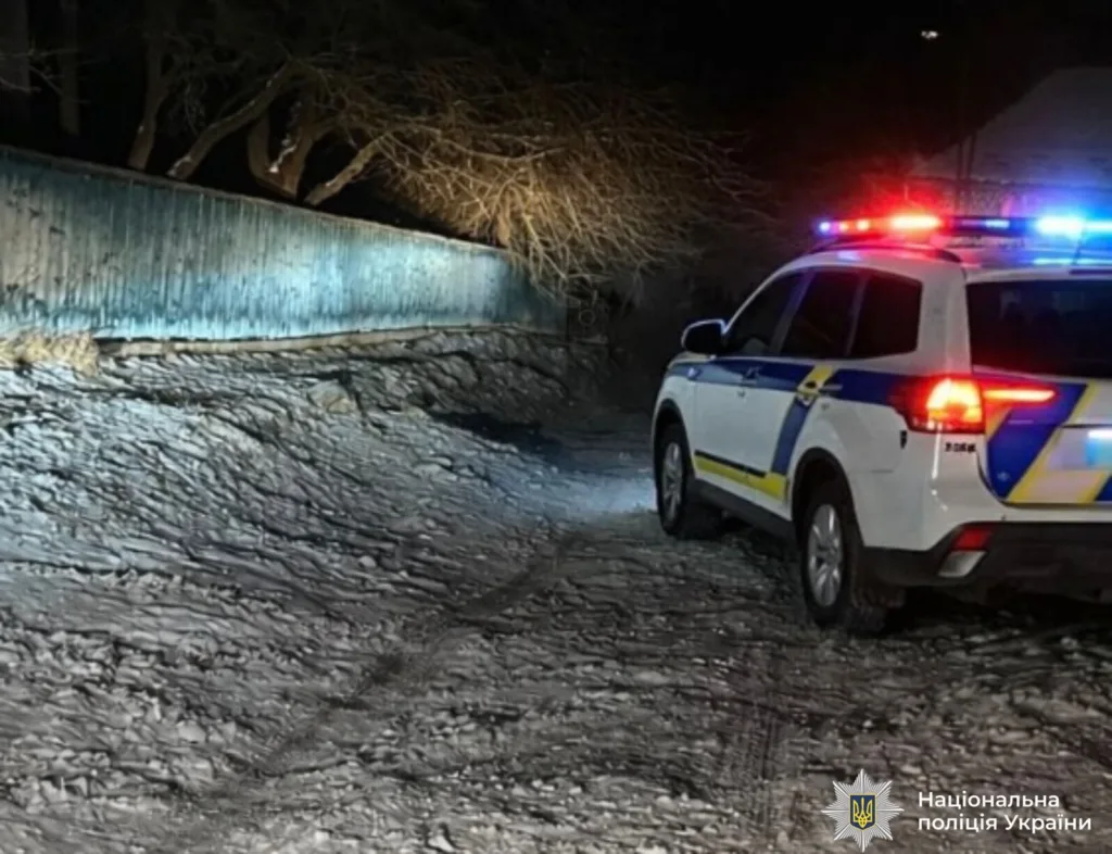 Поліцейський автомобіль на засніженій дорозі вночі
