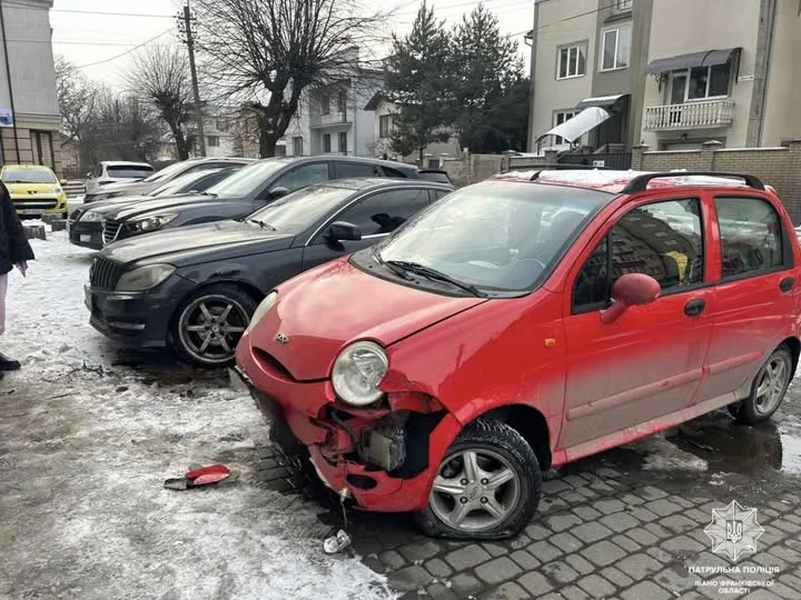 Пошкоджене червоне авто після аварії на парковці