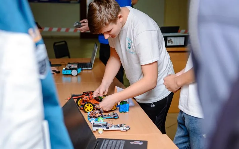 Студенти збирають роботів на занятті з робототехніки