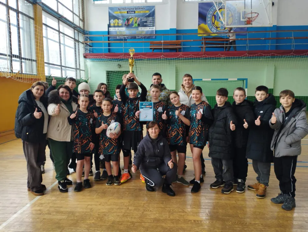 Команда дітей з кубком у спортивному залі