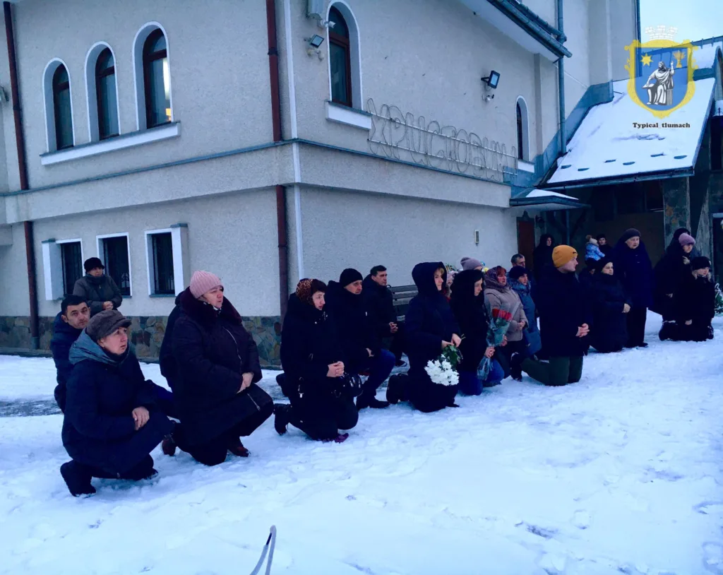 Люди на колінах біля церкви взимку