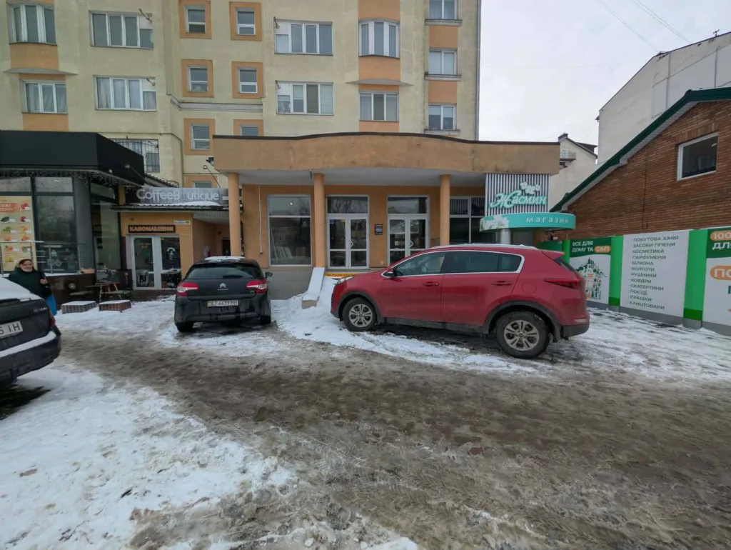 Магазини та кав'ярня біля житлового будинку взимку