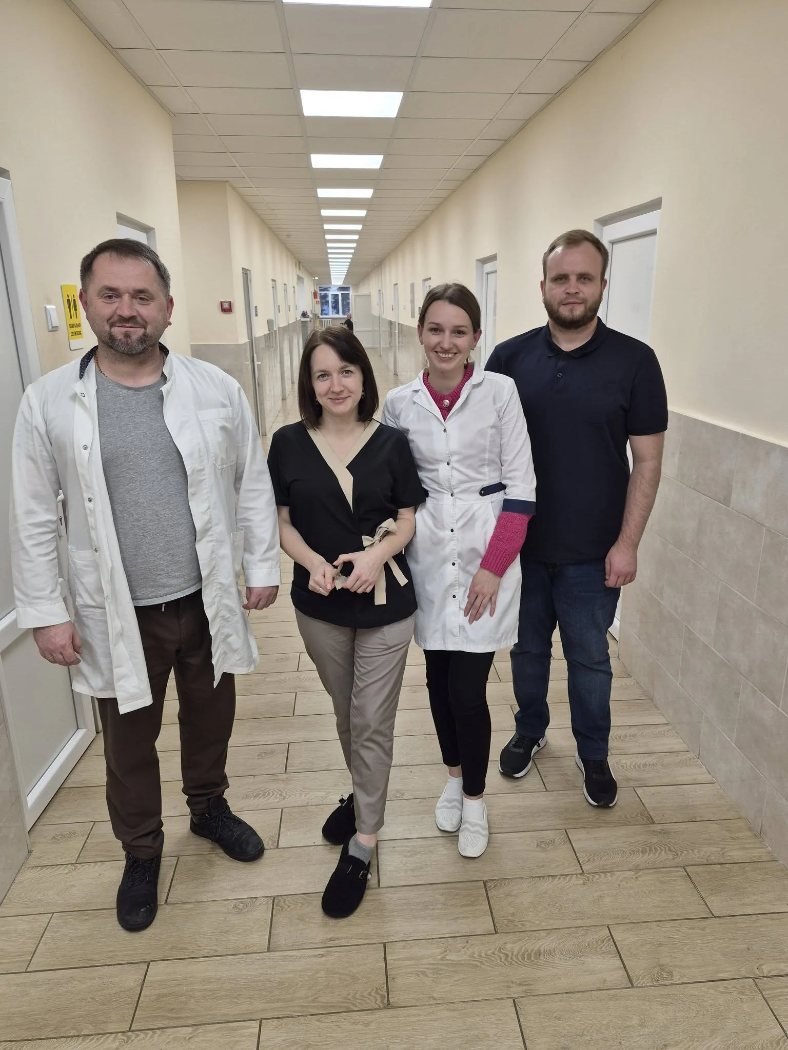 Четверо медпрацівників стоять у лікарському коридорі