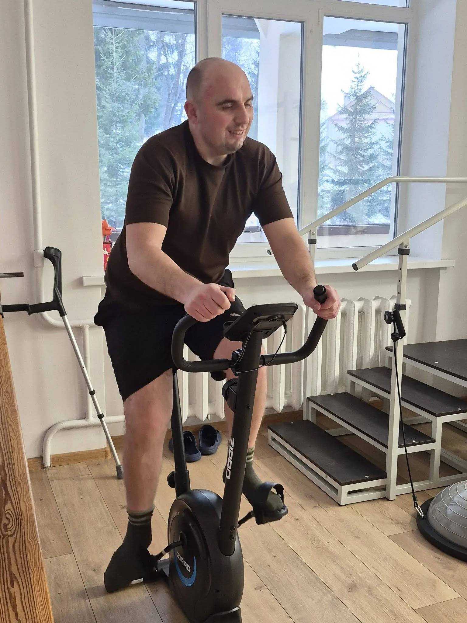 Чоловік тренується на велотренажері у спортзалі