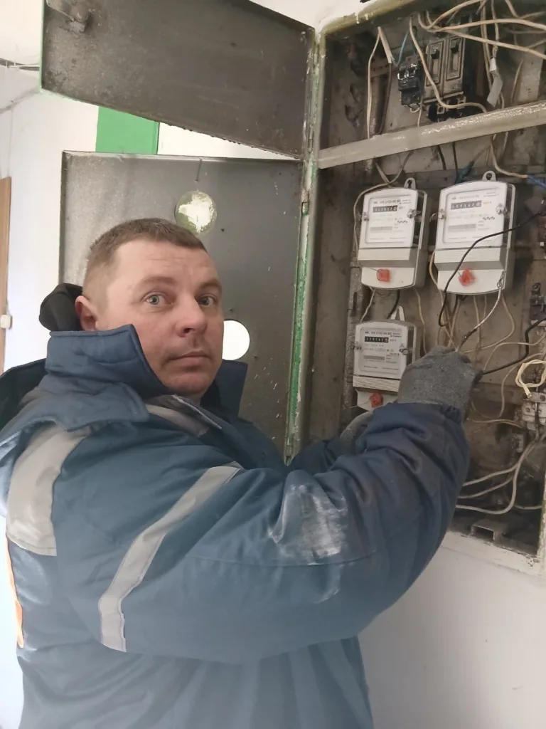 Електрик перевіряє електролічильники у щитку