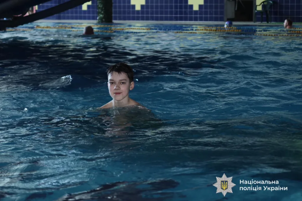 Хлопець плаває у басейні