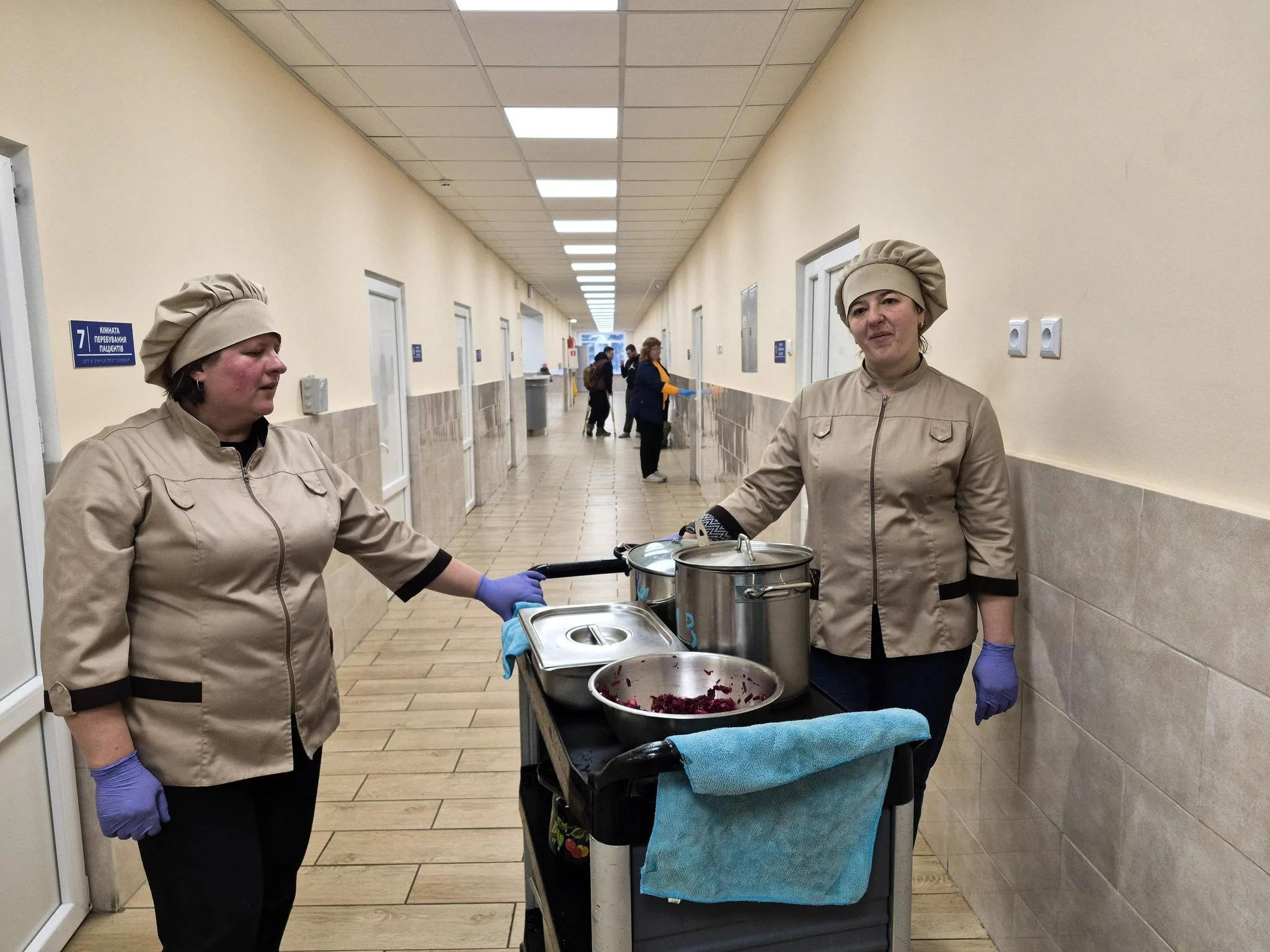 Кухарі роздають їжу в коридорі лікарні