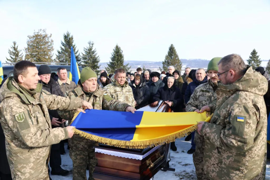 Військові накривають труну українським прапором