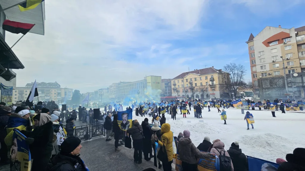 Мирний мітинг людей із прапорами в зимовому місті