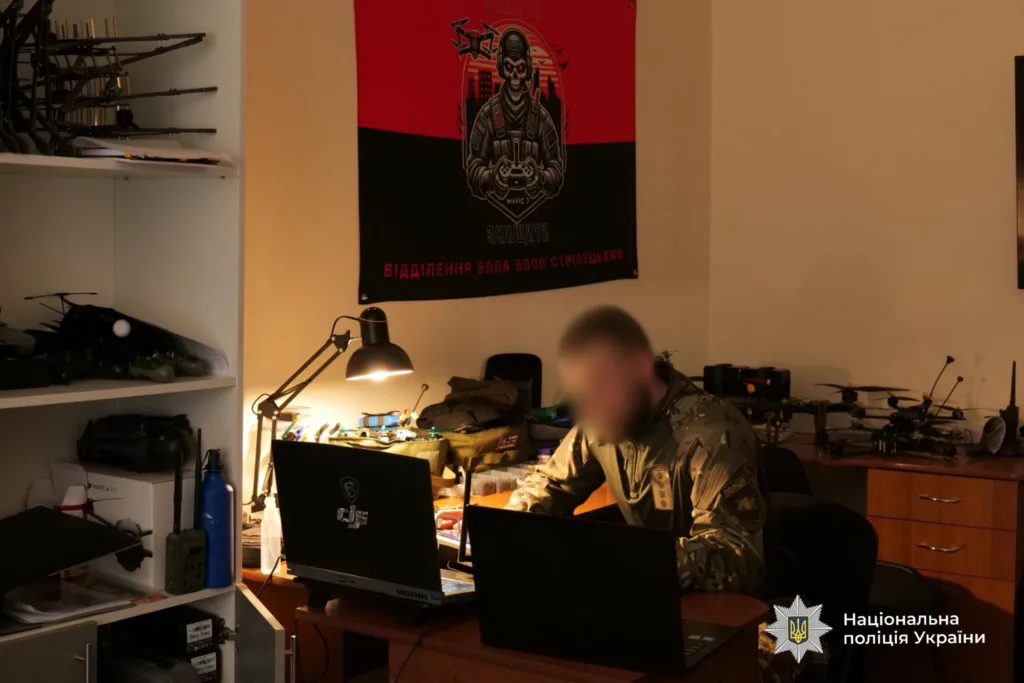 Поліцейський працює за ноутбуками у робочому кабінеті