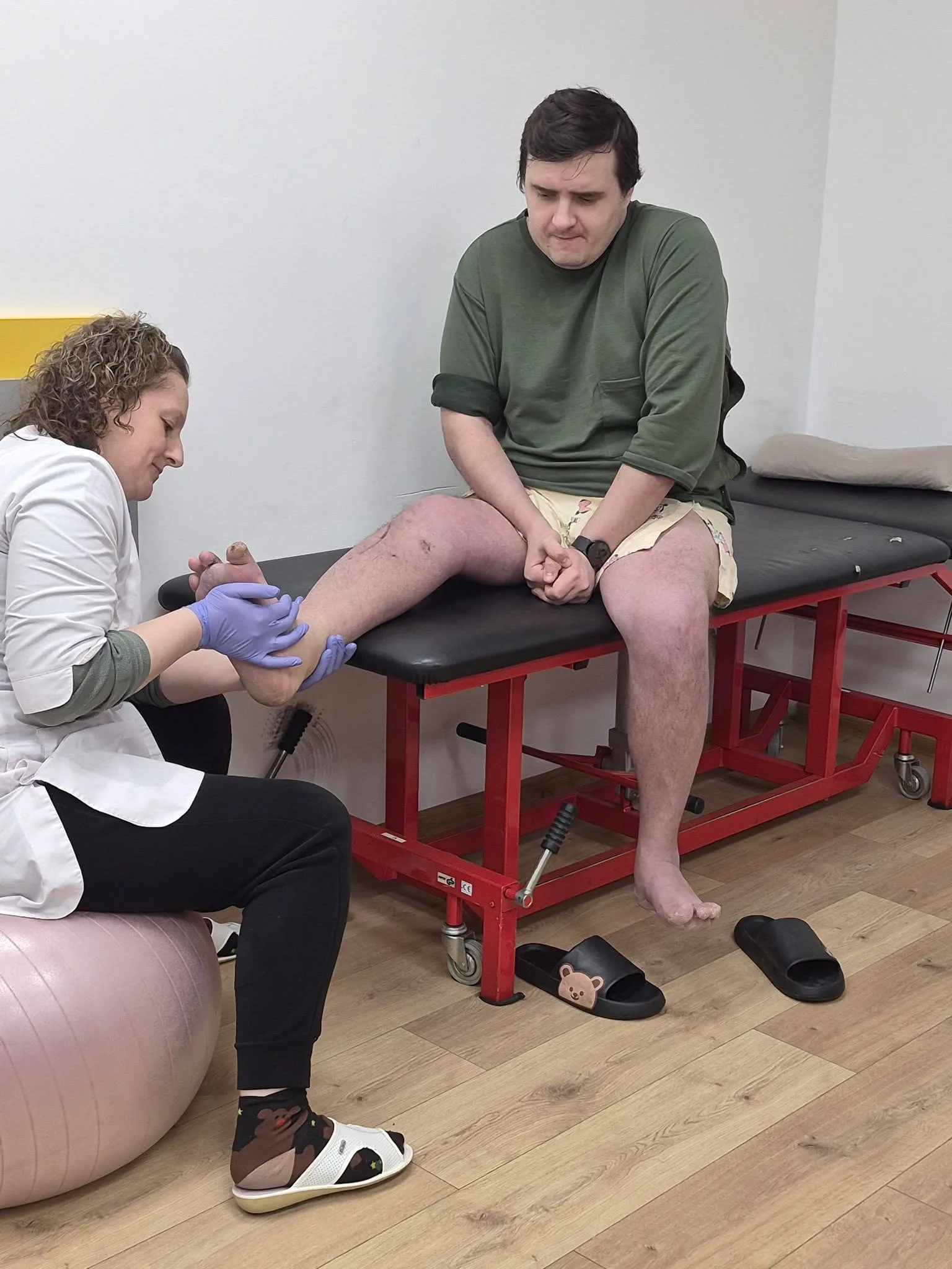 Фізіотерапевт працює з ногою пацієнта на процедурі
