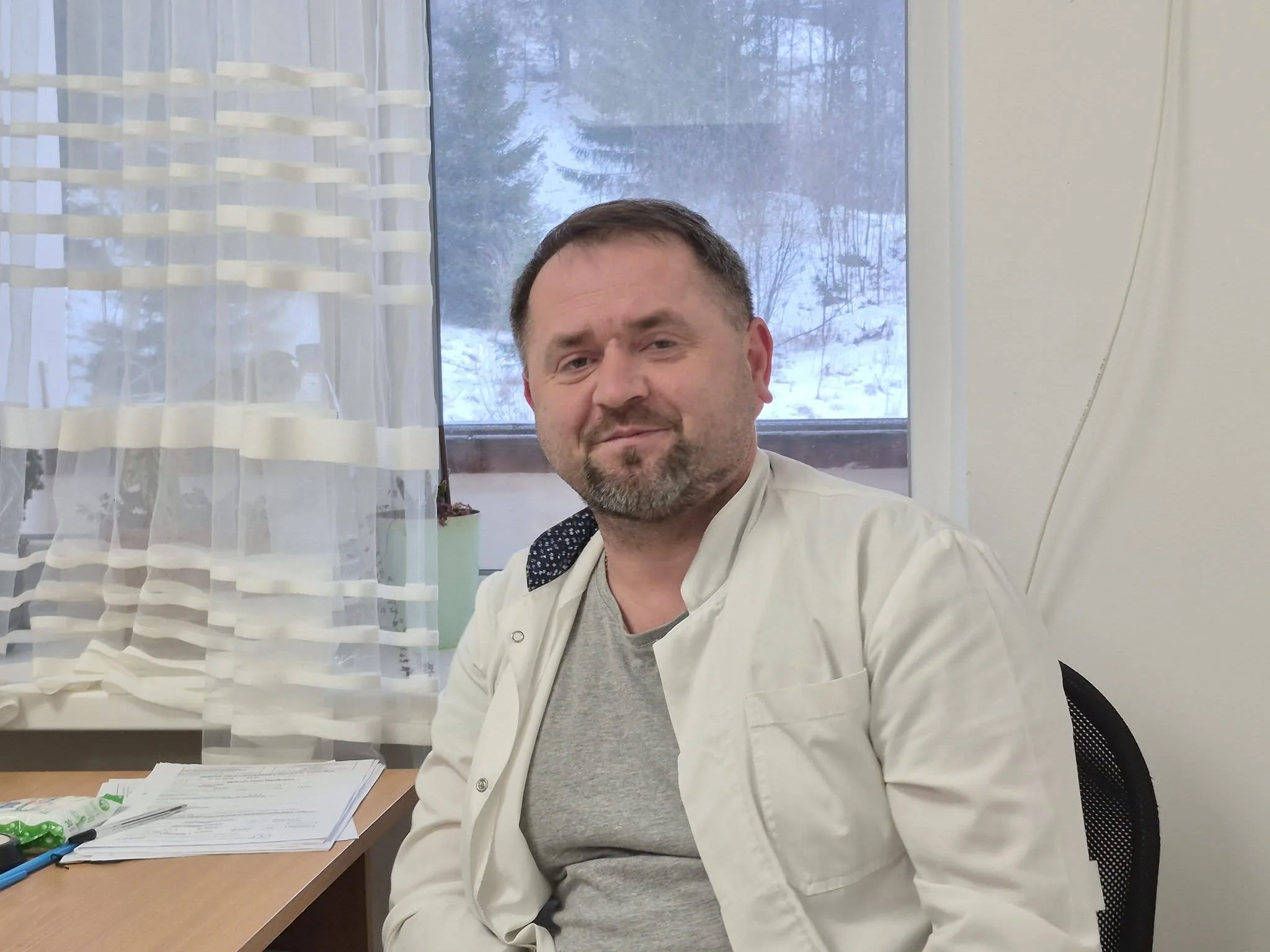 Чоловік у білому халаті сидить у кабінеті