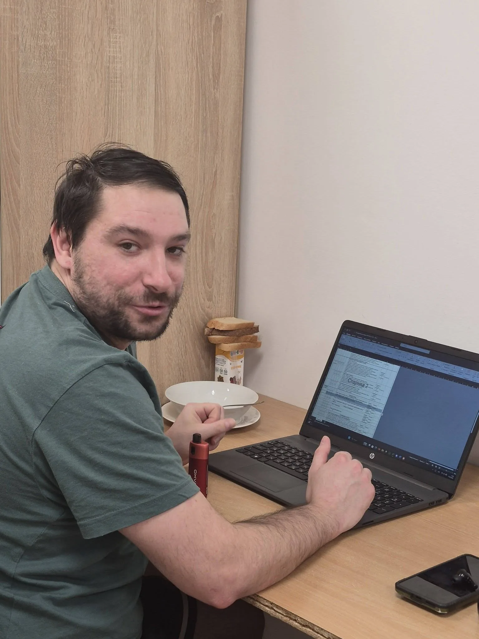 Чоловік працює за ноутбуком у домашньому офісі