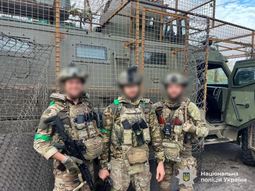 Українські військові перед броньованим транспортом