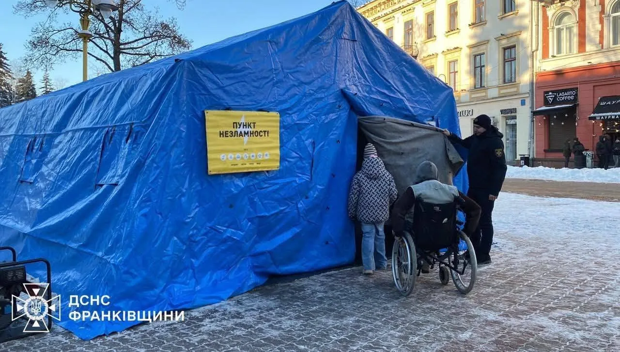 Люди біля пункту незламності у синьому наметі