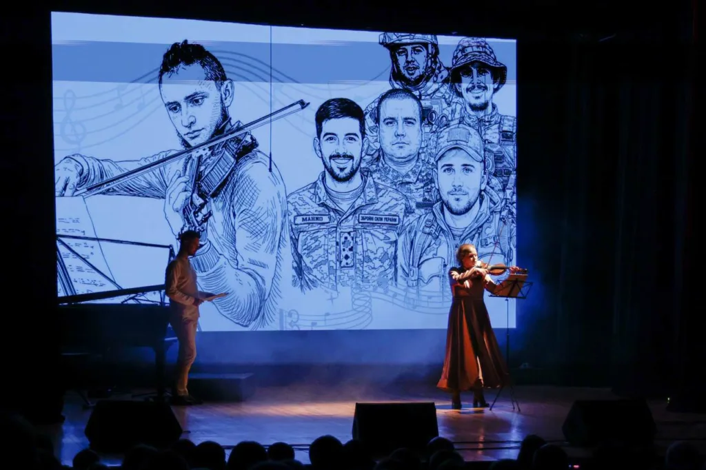 Скрипалька виступає перед малюнком українських військових