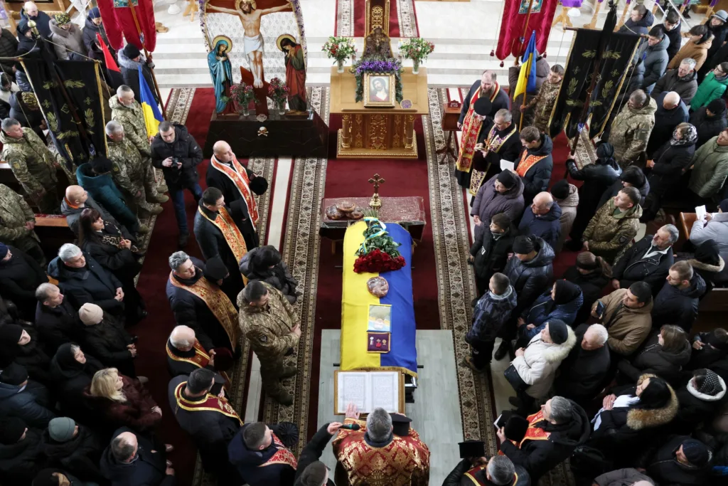 Похоронна церемонія у церкві з українським прапором