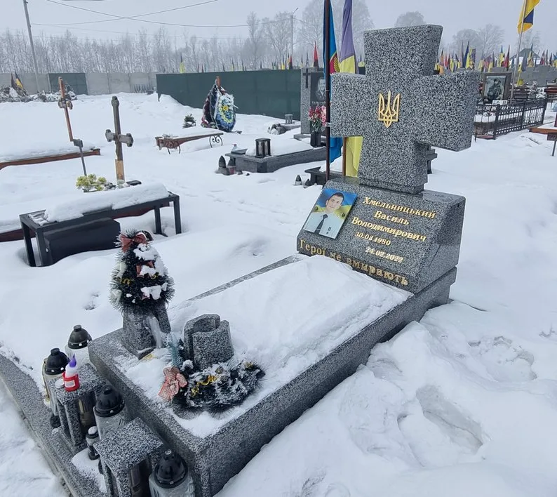 Засніжена могила українського військового з прапорами