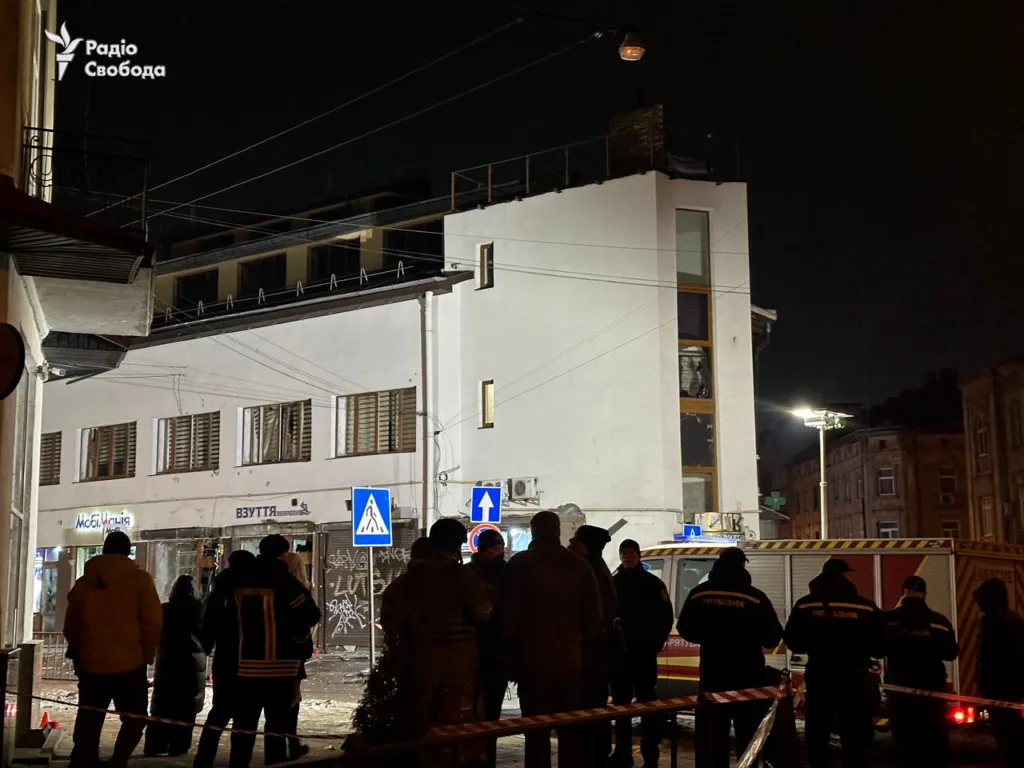 Рятувальники біля пошкодженої будівлі вночі