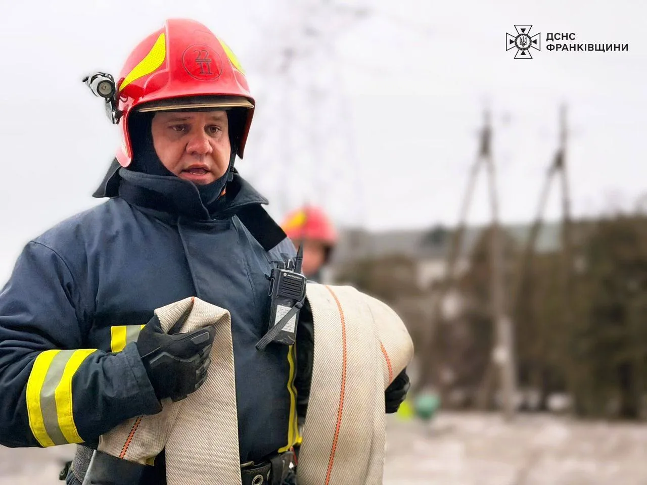 Пожежник тримає пожежний рукав на вулиці