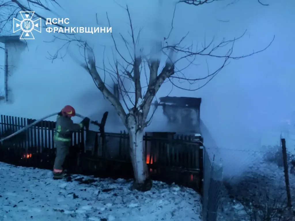 Пожежник гасить пожежу в будинку взимку