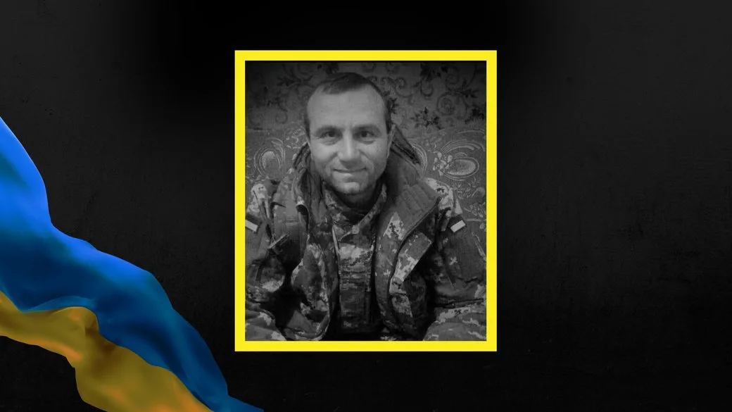 Український військовий у камуфляжі на темному фоні