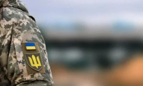 Український військовий у камуфляжі з прапором України