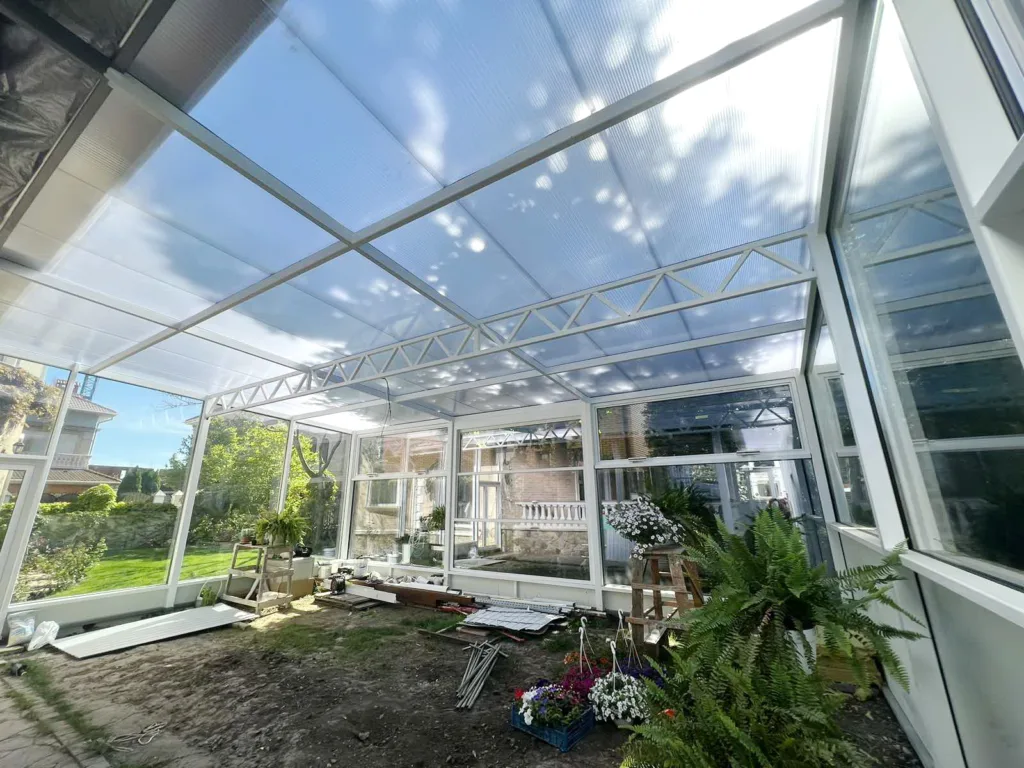 Сонячна тераса з прозорим дахом і рослинами