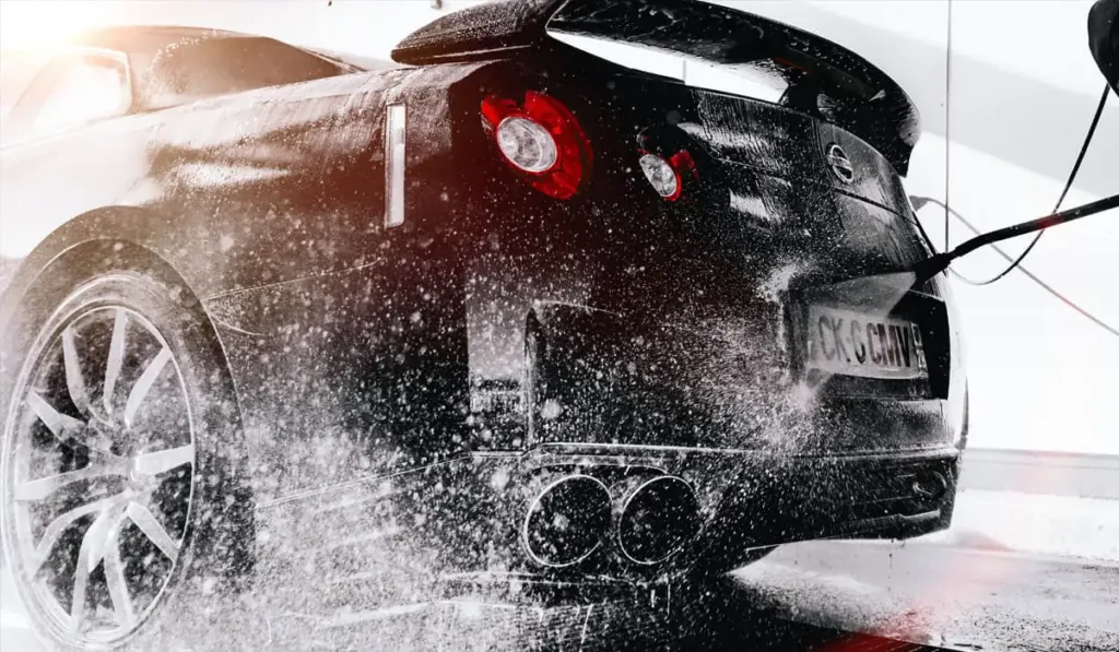 Миття чорного спортивного автомобіля під тиском