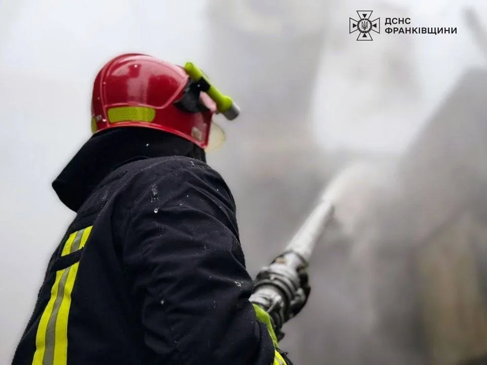 Пожежник гасить вогонь водяним шлангом