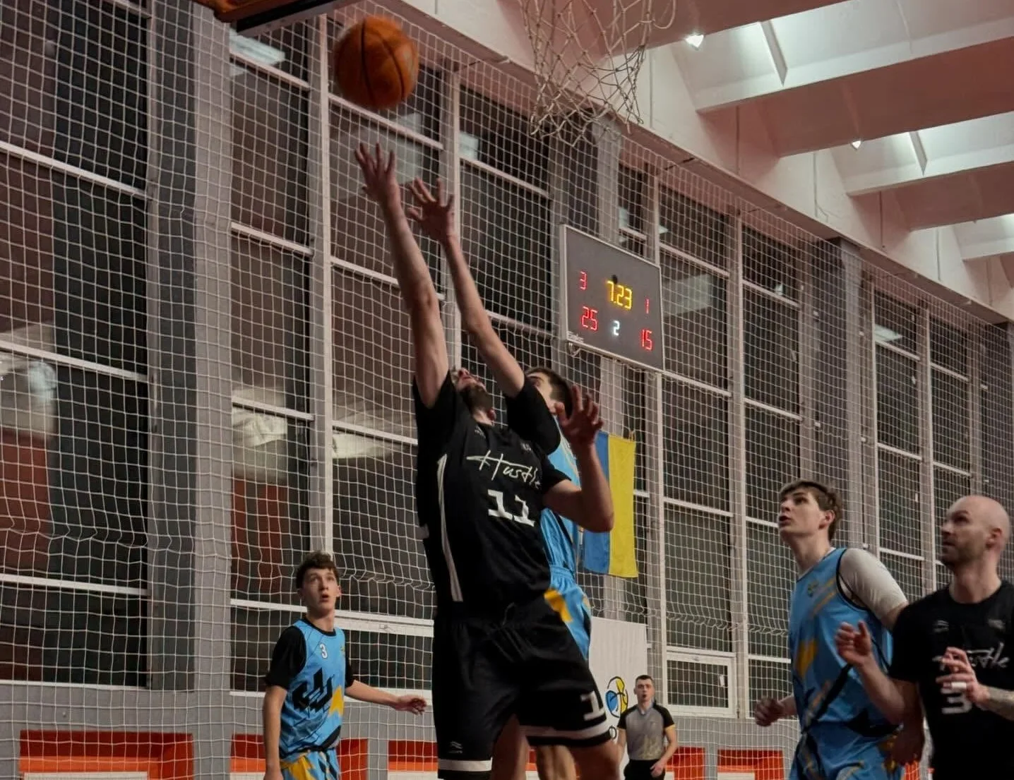 Баскетболісти змагаються за м'яч біля кошика