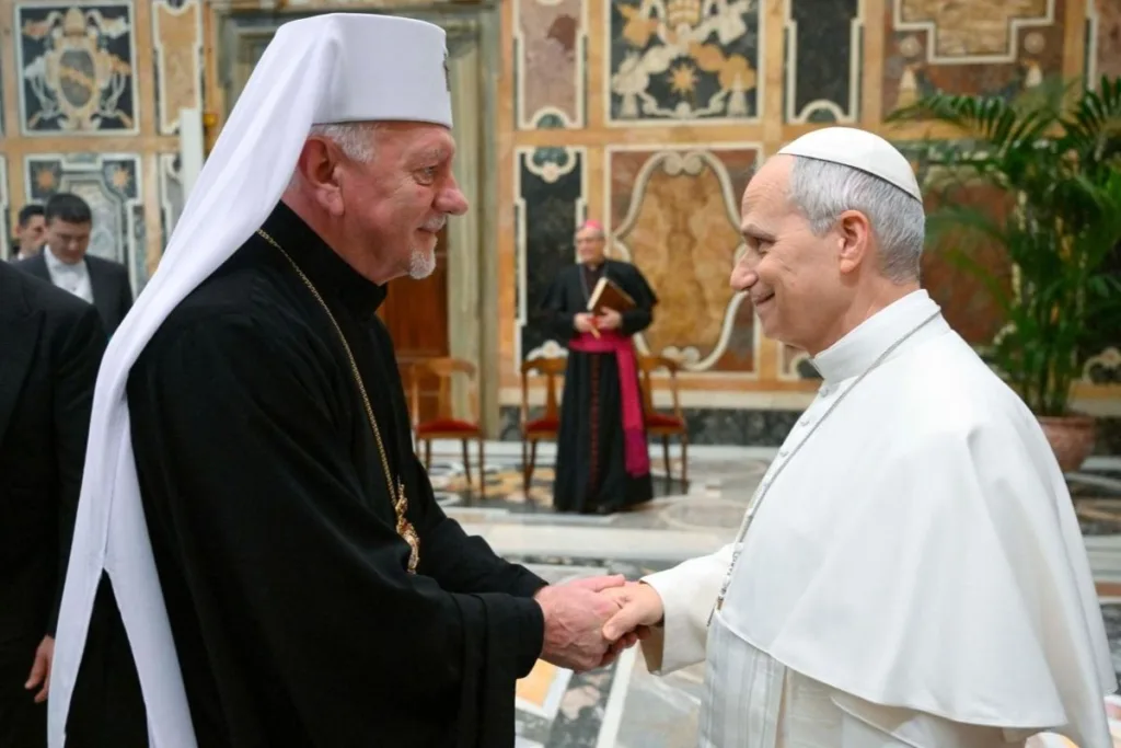 Двоє священників тиснуть руки у храмі