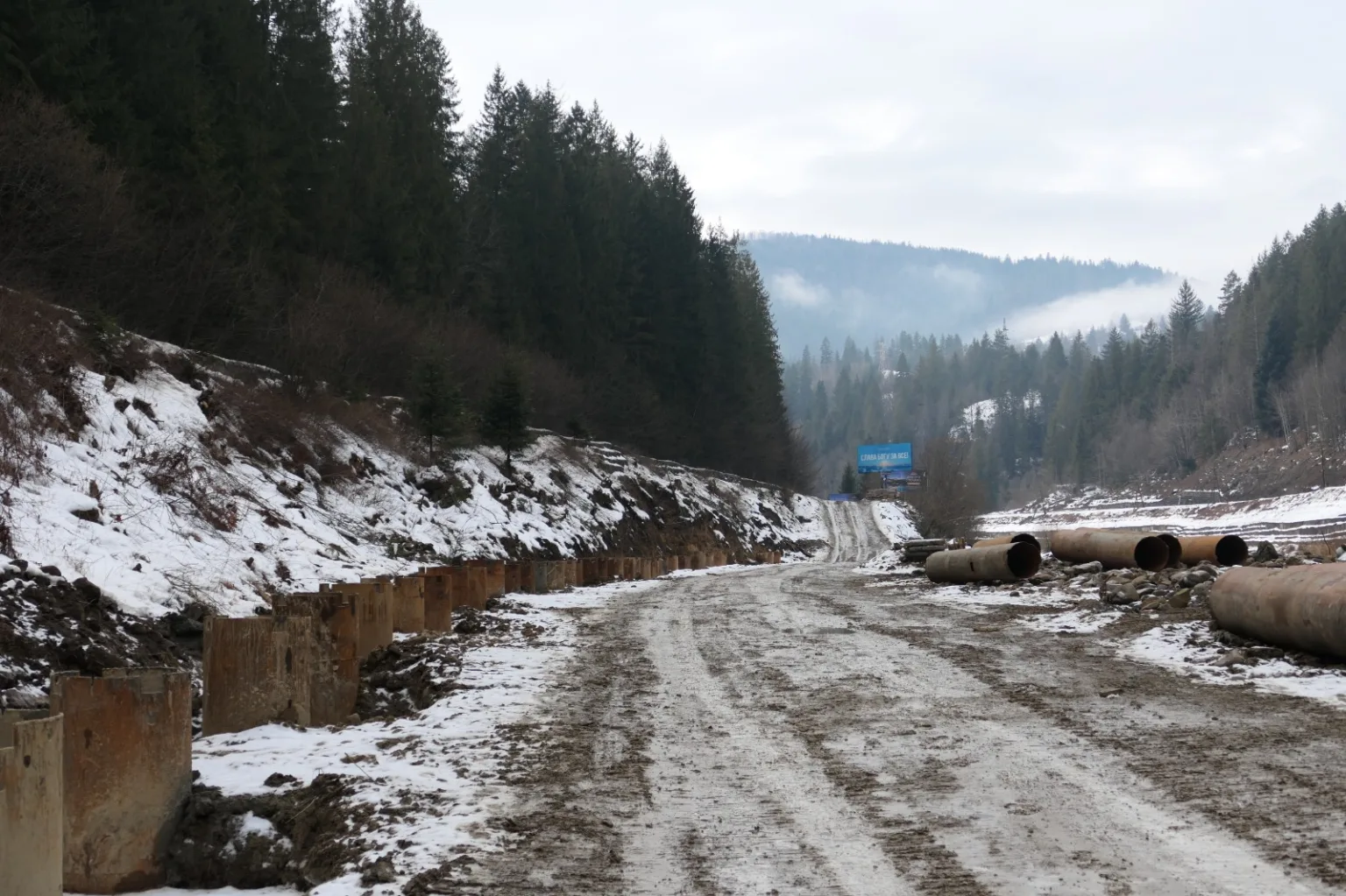 Зимова гірська дорога з трубами і снігом
